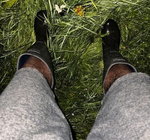 Male legs in shorts and wellies standing on grass